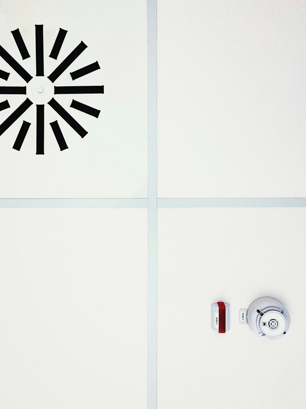 Detector and alarm sounder on a white ceiling